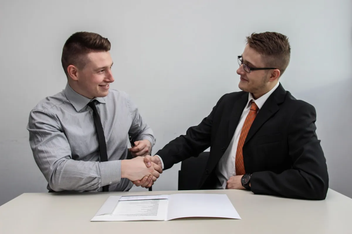 Two business professionals shaking hands in agreement, representing the trust and partnership involved in choosing a reputable gold dealer