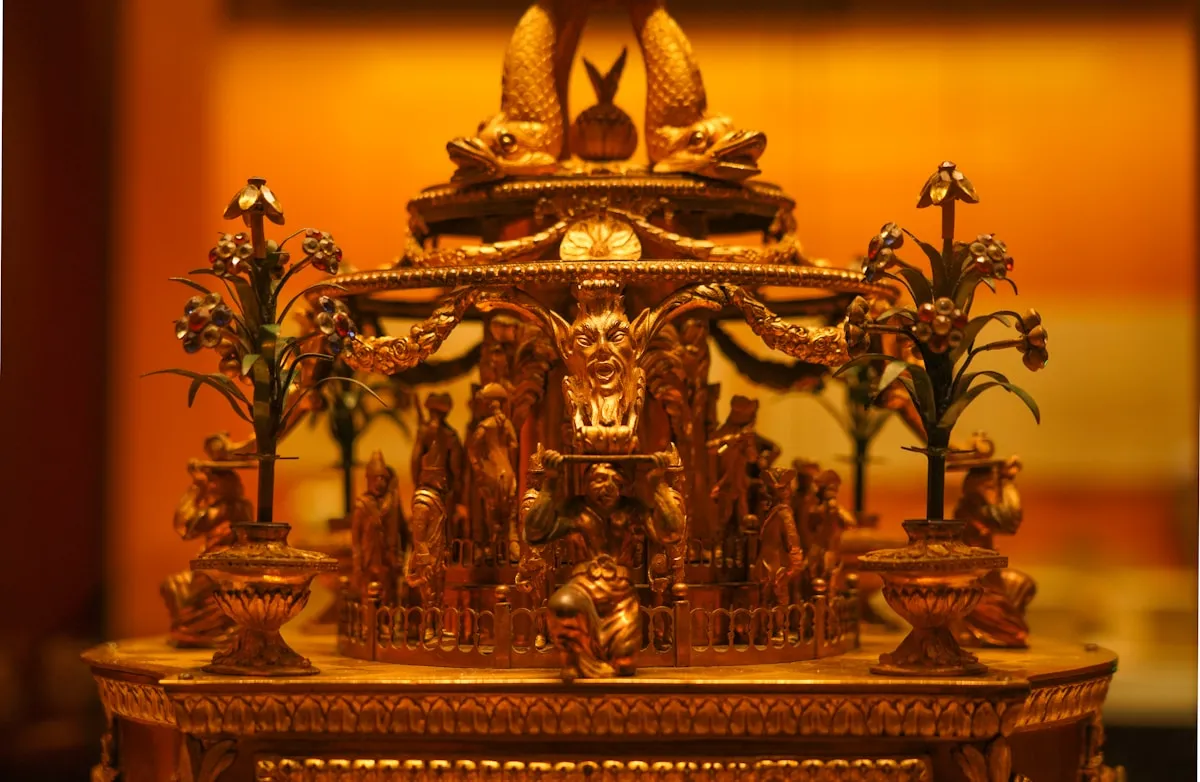 A serene gold Buddha figurine on a table, embodying Buddhism’s use of gold to represent enlightenment’s radiant perfection