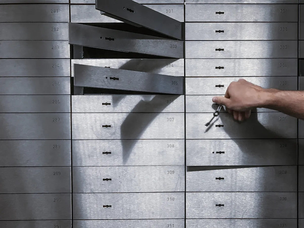 Hand holding keys in front of a locker, representing access to secure storage facilities for precious metals