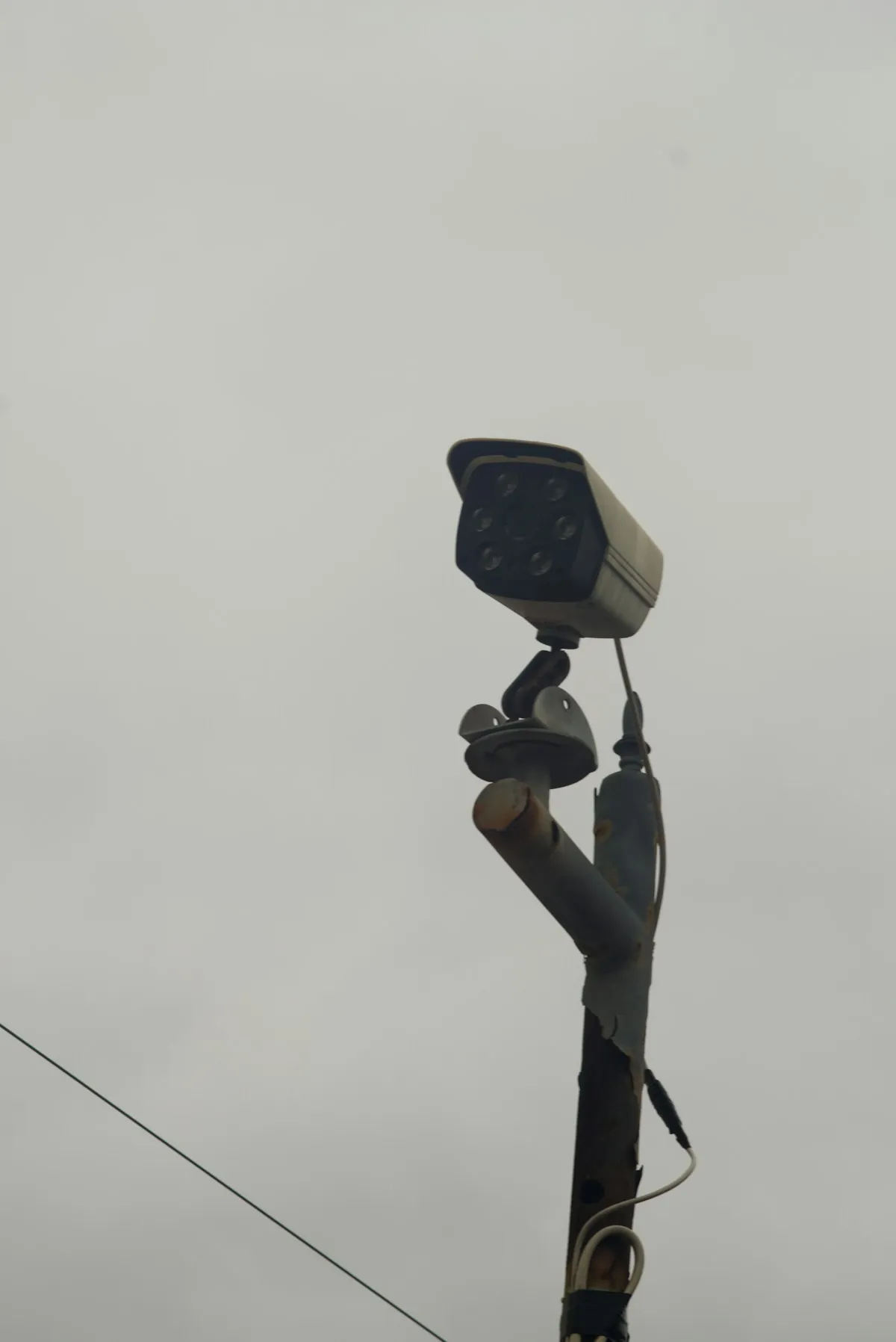 A security camera mounted on a pole against a blue sky, representing the surveillance and monitoring systems that provide early warning when disasters threaten