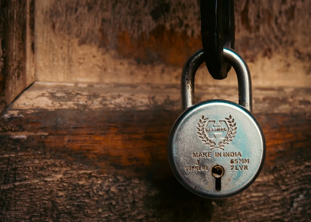 A vintage padlock resting on a weathered wooden surface, representing the timeless principle that concealment and misdirection remain powerful security tools