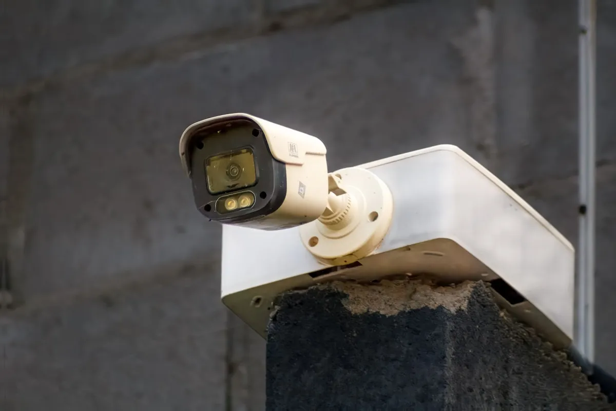 A security camera mounted on an exterior wall, outdoor cameras cover entry points and provide early warning of approaching visitors